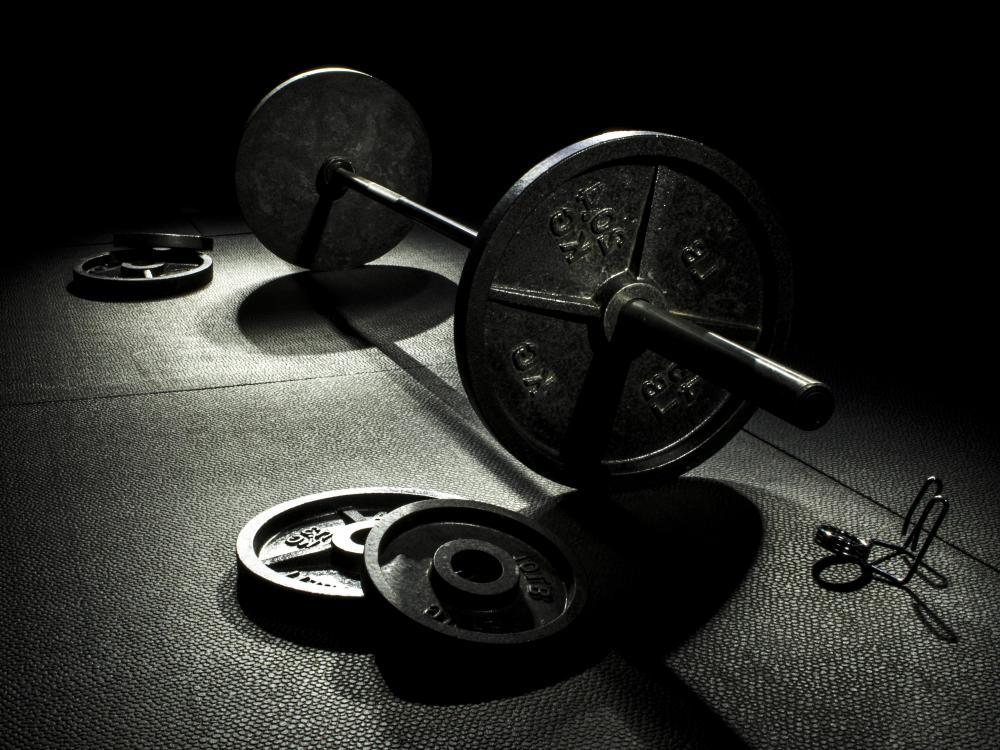 A barbell sits behind a person's ankles before being lifted during a hack squat.