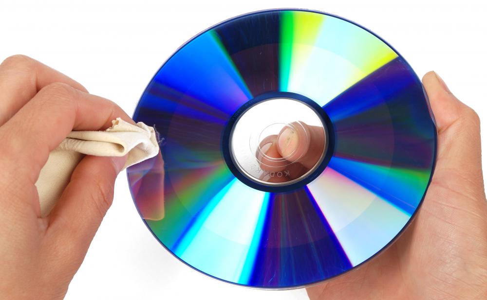A person cleaning a CD with a microfiber cloth.