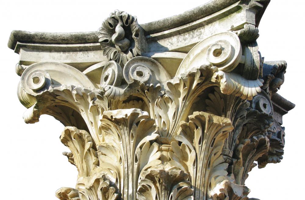 A Corinthian capital has an elaborate design that includes Ionic volutes and floral elements.
