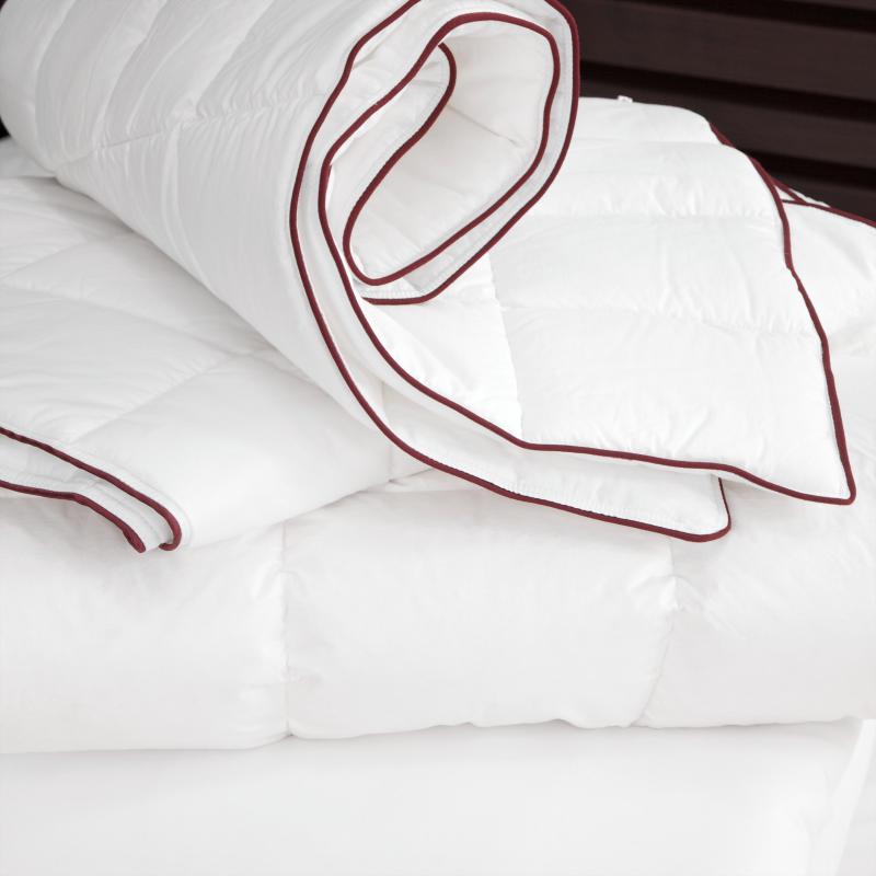 A crimson tipped duvet without a duvet cover.