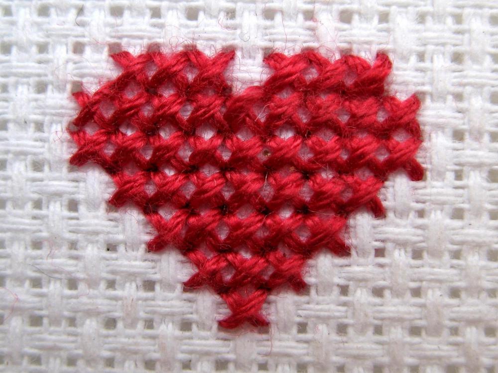 Cross stitch features an intersecting stitch that forms an "X" or cross pattern.