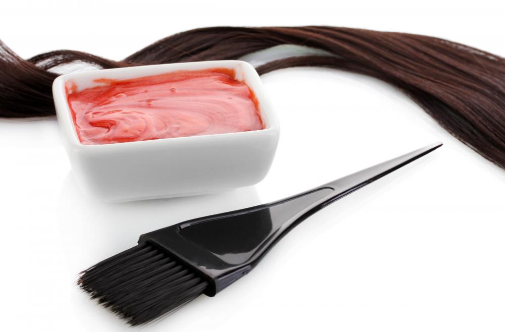 A hair color specialist mixes hair color chemicals and applies the color to the hair.