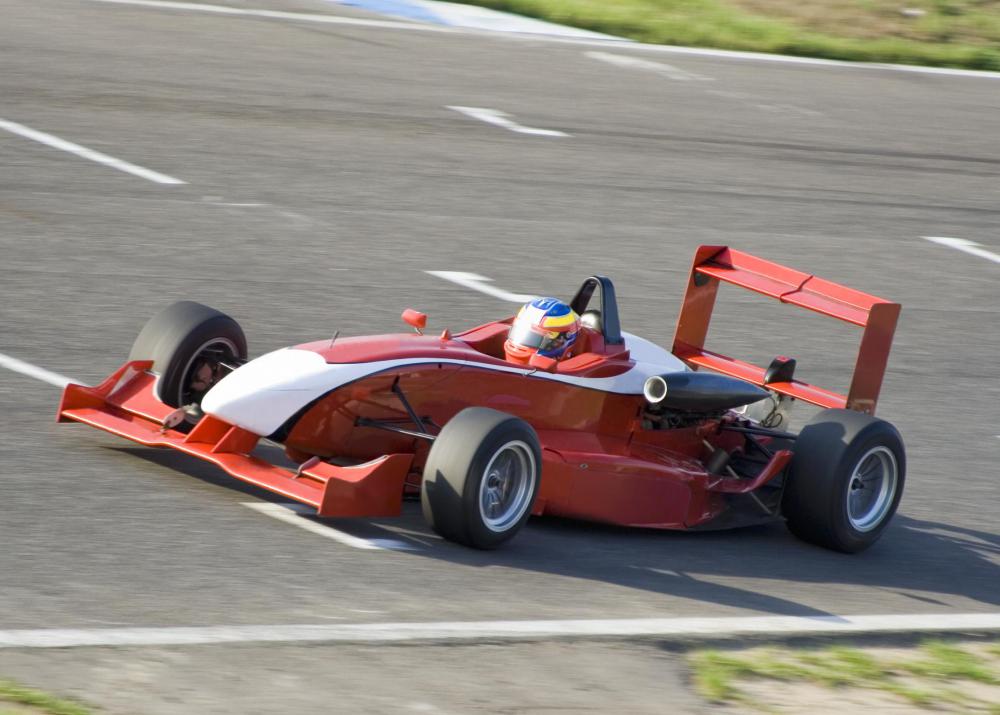 A racecar's spoilers and tailfins generate a downward force that helps it stay on track during tight turns.