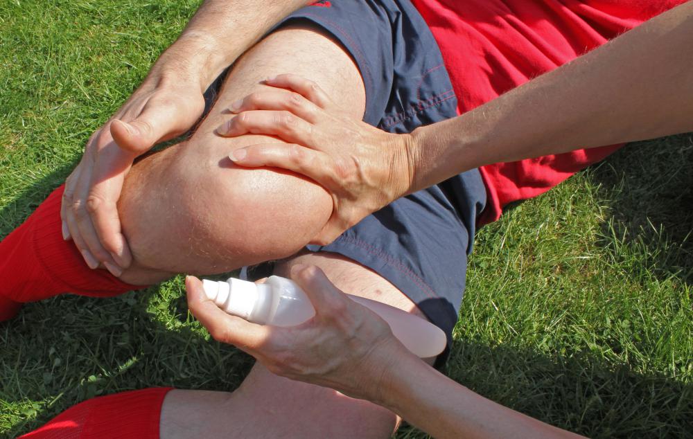 An athletic trainer provides first aid when an athlete is injured on the field.