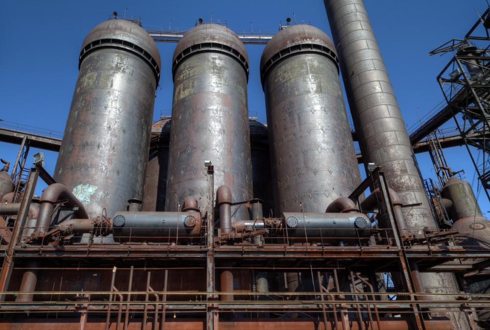 The heat generated inside towering blast furnaces is used to create pig iron from a mixture of iron ore, coke, and limestone.
