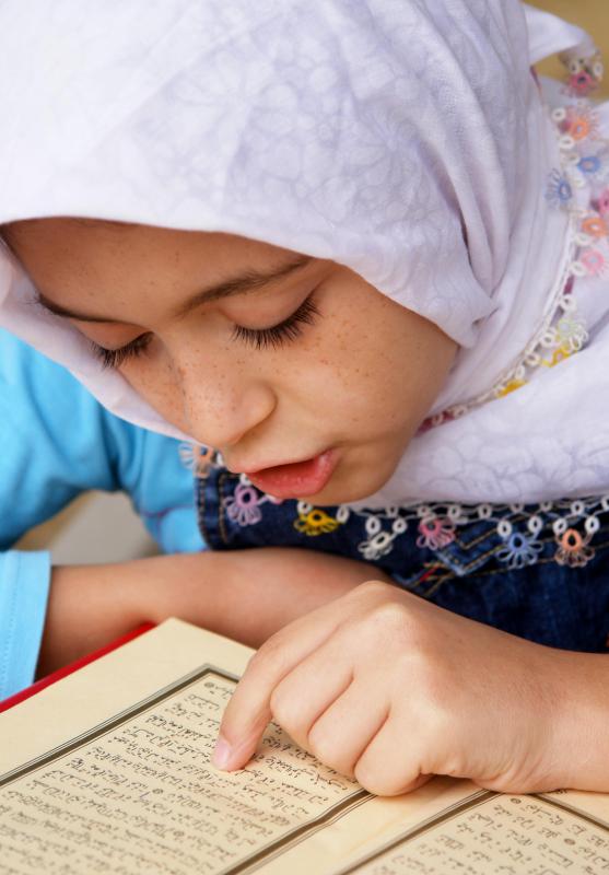 A young Muslim girl reading the Qur'an.