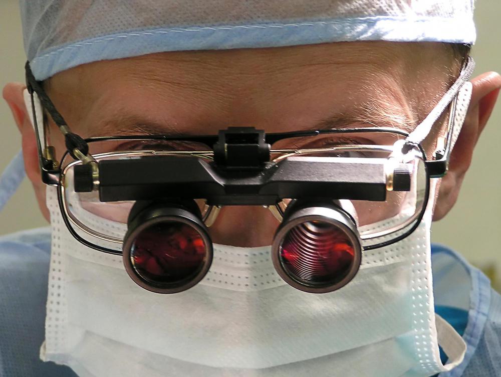 Surgical loupes are small magnifying lenses that can be worn over the eyes or eyeglasses during surgery.