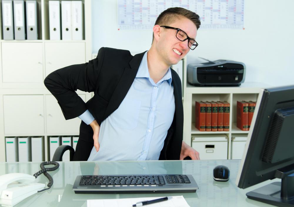 Long periods of sitting at a desk with poor posture can cause back pain.