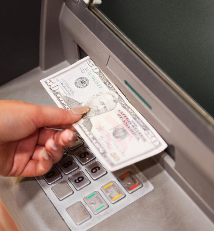 A woman withdrawing cash from an ATM.