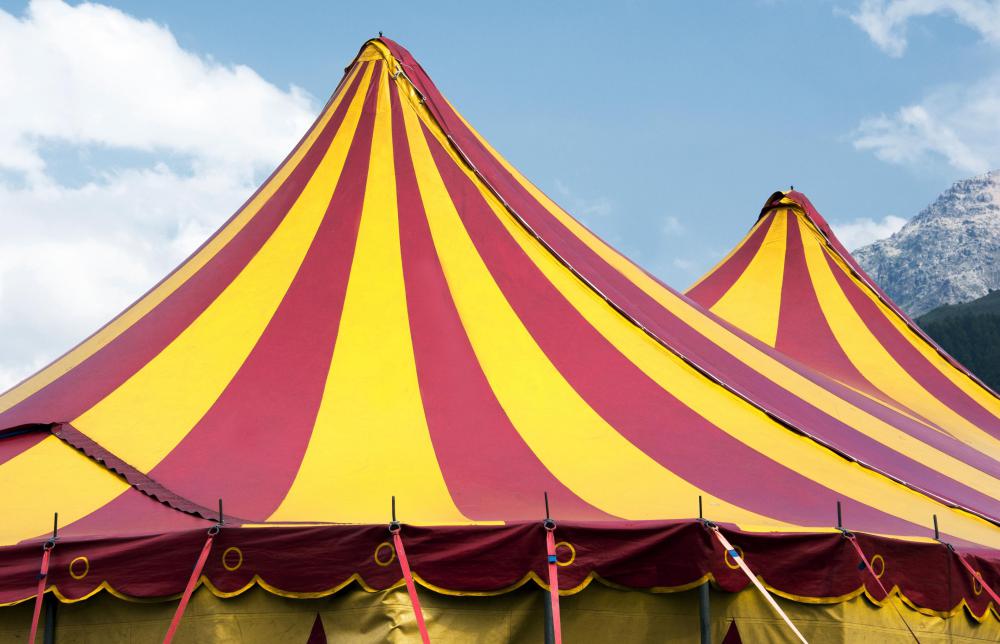 The classic setting for a circus is under a brightly colored tent.