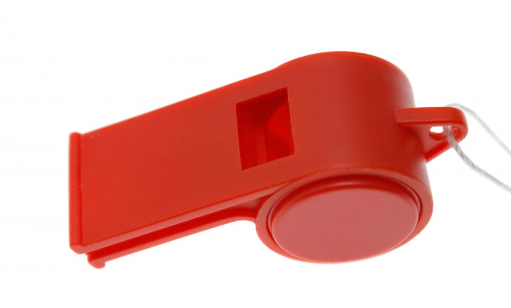 A soccer referee may blow a whistle to indicate violations of game rules.