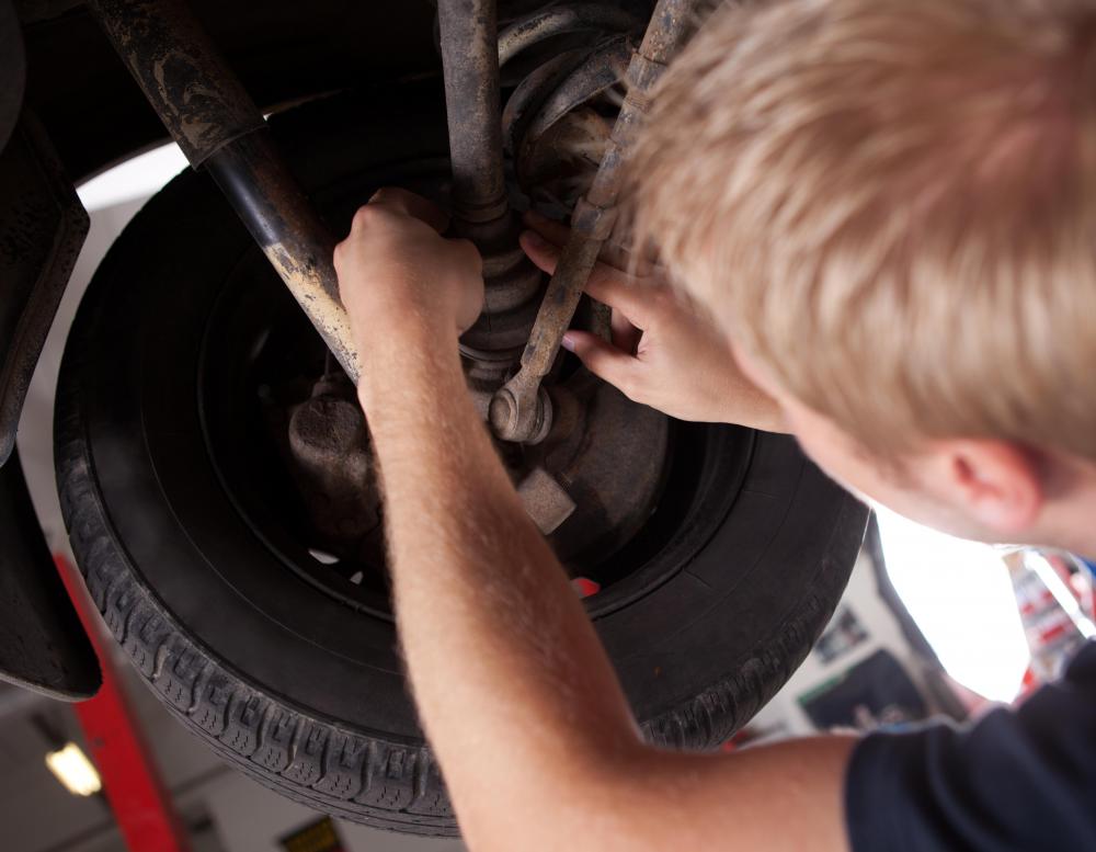 A person repairing a CV joint on a car.