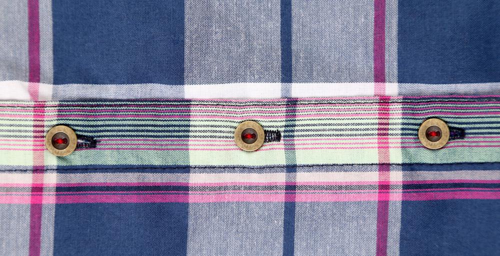 A sewing gauge may be used to ensure the uniformity of the distance between buttons on a fabric.