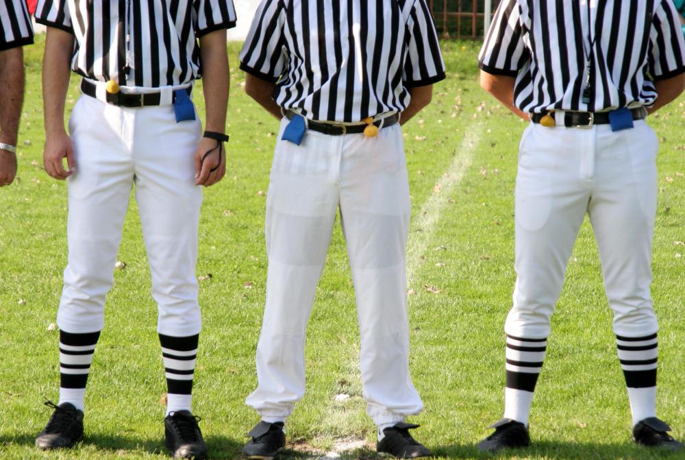 Multiple officials oversee a football game.