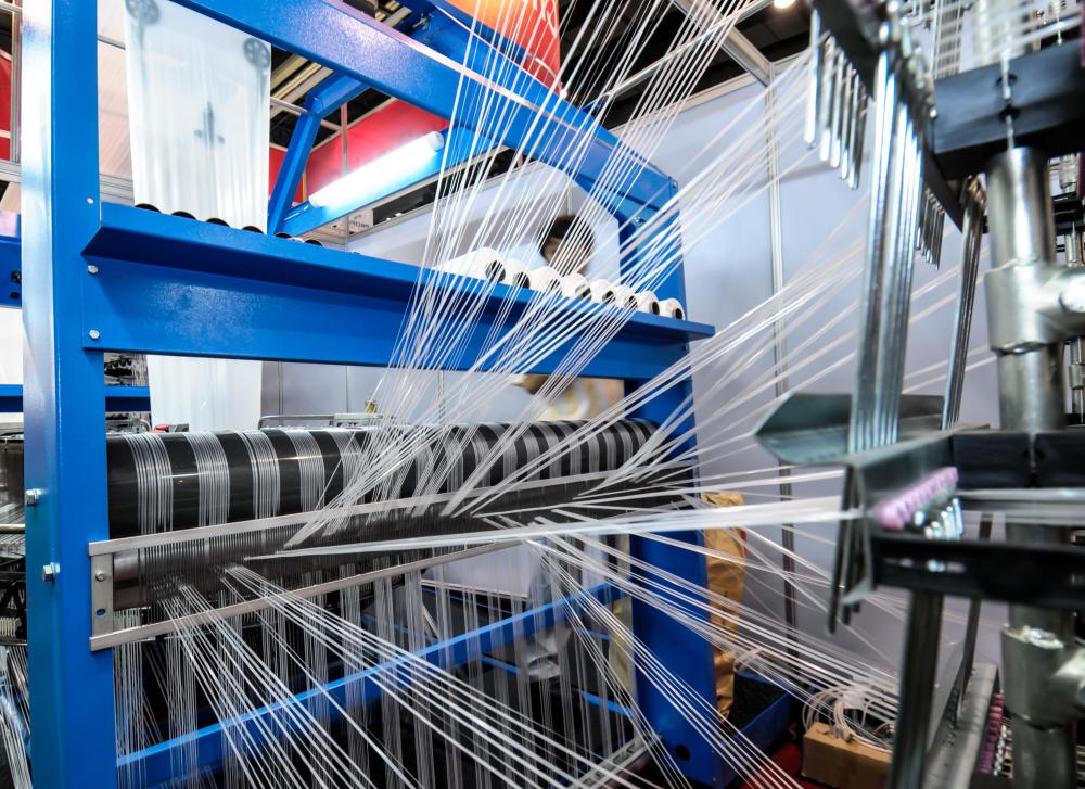 Mechanical looms leave cotton yarn into fabric.