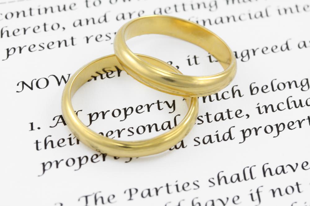 Wedding bands atop a marriage contract excerpt.