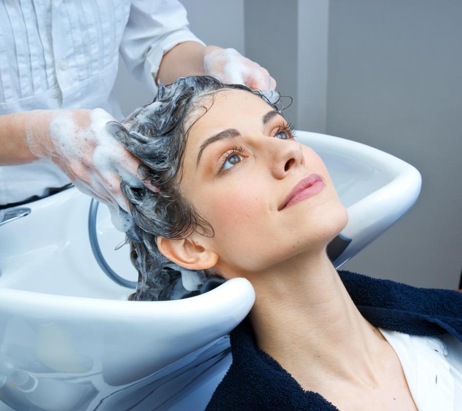A shampoo cape is worn in a salon to prevent an individual from getting wet.