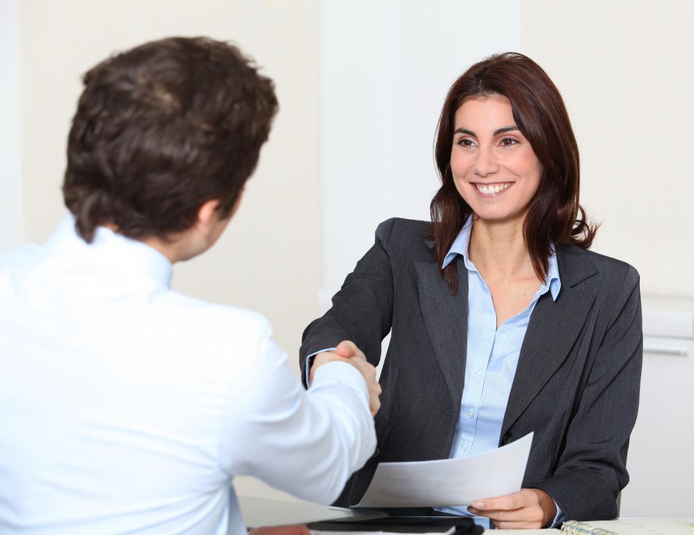 A human resources employee shaking hands with a new hire.